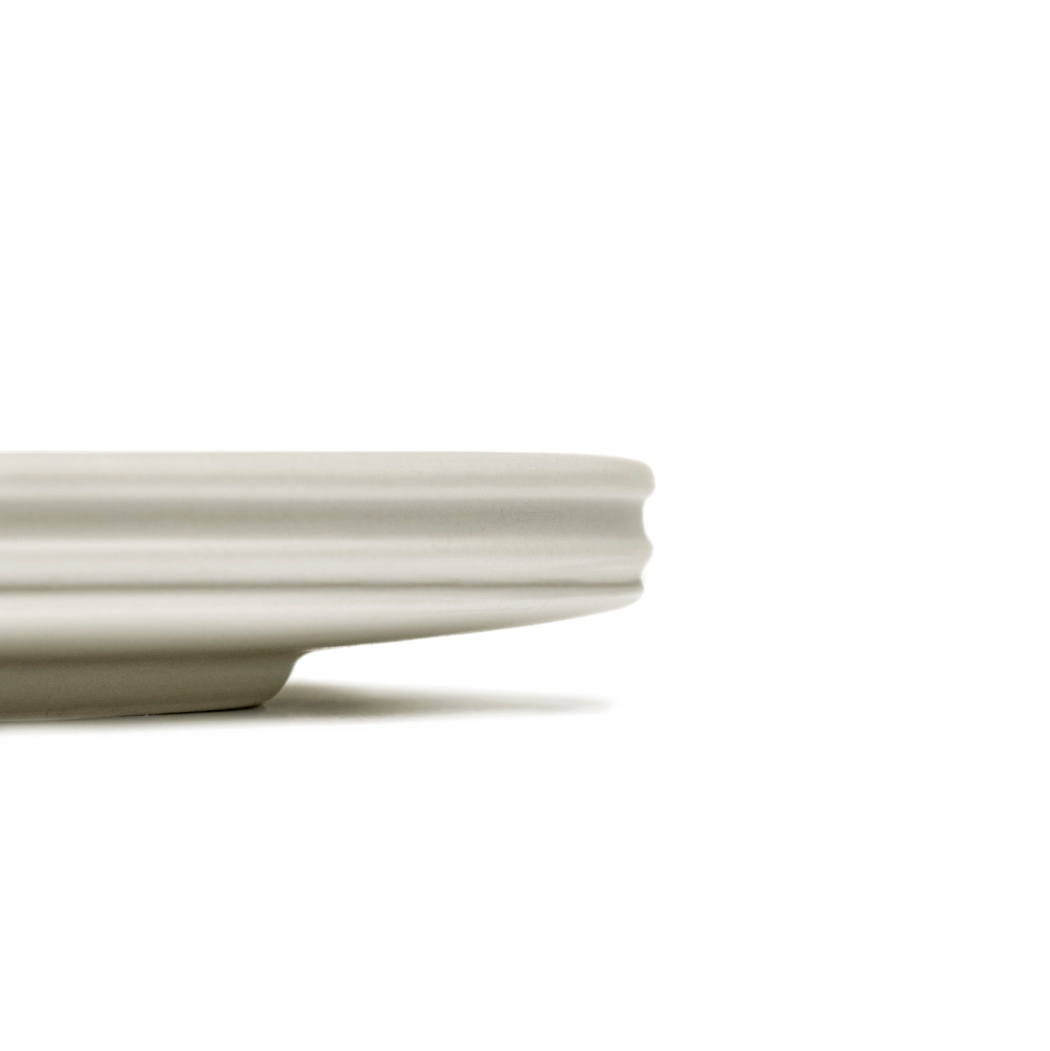 Een close-up van de Serax Dune Laag Bord Alabaster D33, een effen, rond, lichtgekleurd keramiek bord uit de Dune collectie van Serax, met de elegante rand en randdetails tegen een witte achtergrond.