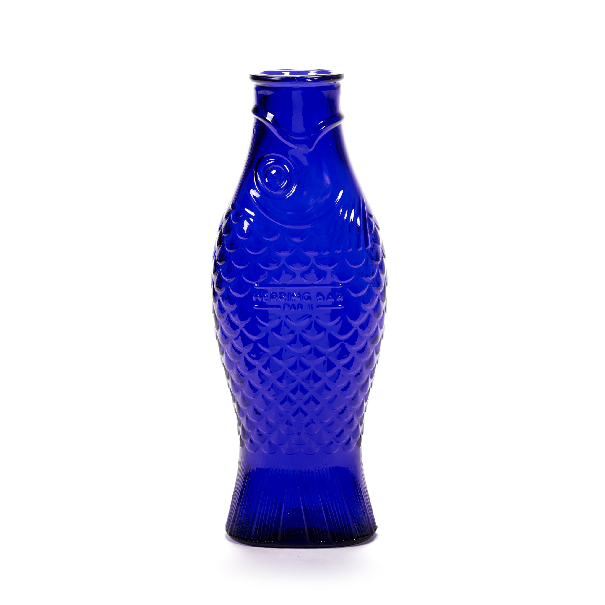 De Serax Fish & Fish Karaf Kobalt Blauw 85 cl is een blauwe glazen karaf in de vorm van een vis, met gestructureerde schubben en details van de vinnen. De karaf is ontworpen door Paola Navone voor Serax en staat rechtop op een witte achtergrond.
