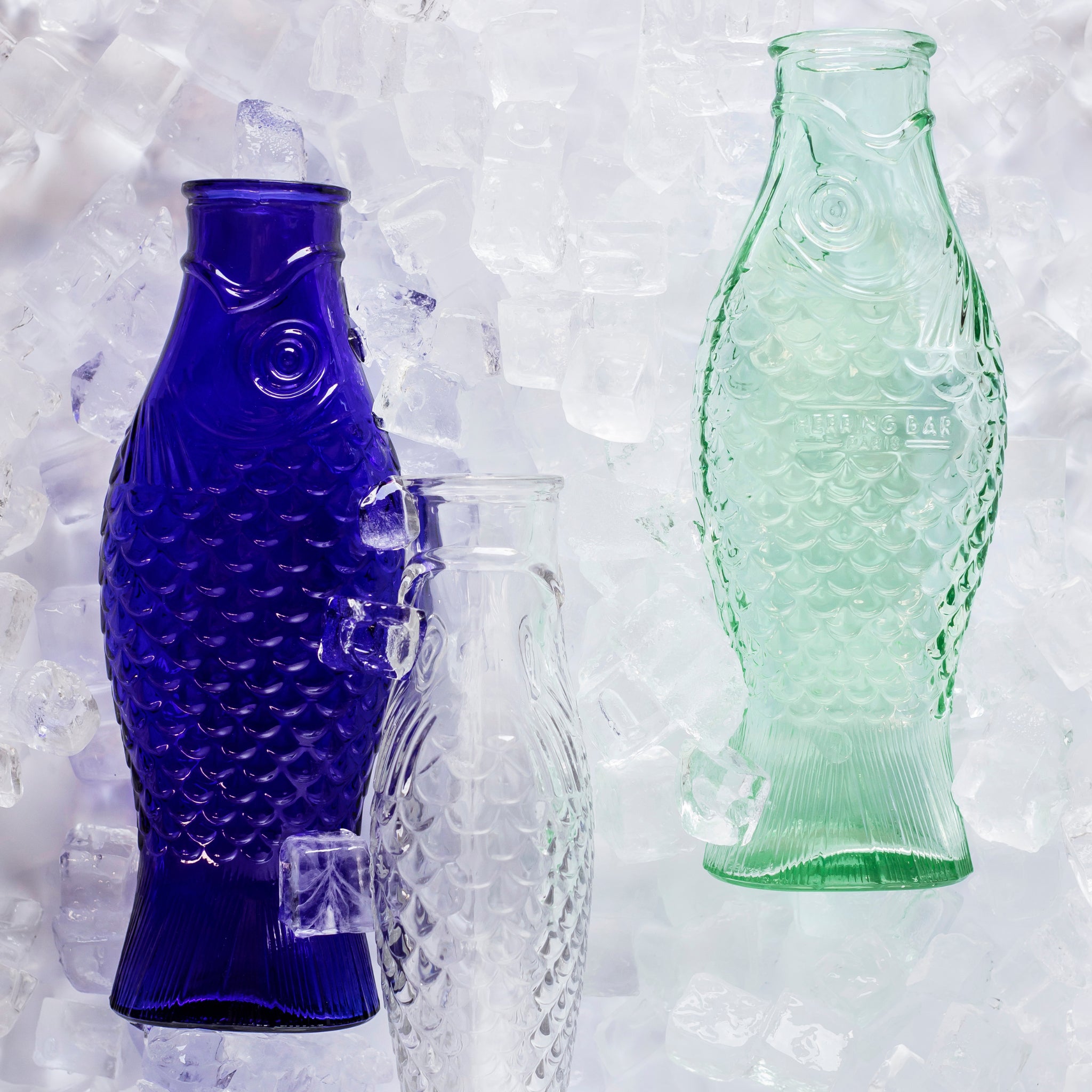 De Serax Fish & Fish Karaf Kobalt Blauw 85 cl staat rechtop op ijs. Ontworpen door Paola Navone, brengen het gestructureerde oppervlak en de visdetails speelse charme in elke omgeving.