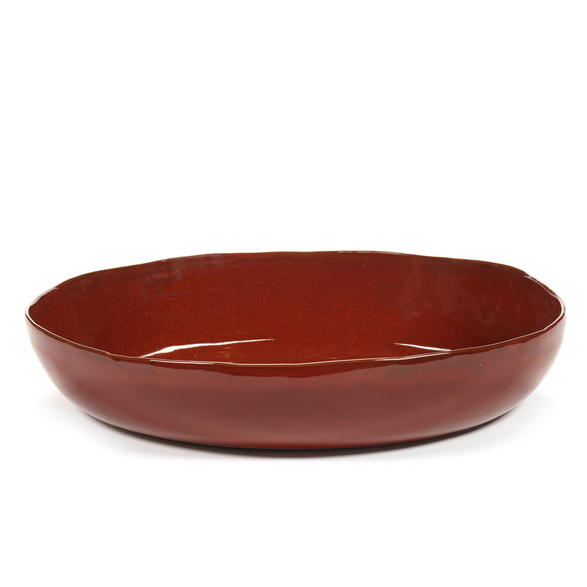 De Serax La Mère Serveerschaal Venetian Rood D37 is een glanzende, ondiepe ronde schaal in donkerrood keramiek met licht onregelmatige randen, geïnspireerd op de La Mère collectie van Marie Michielssen en afgebeeld tegen een witte achtergrond.