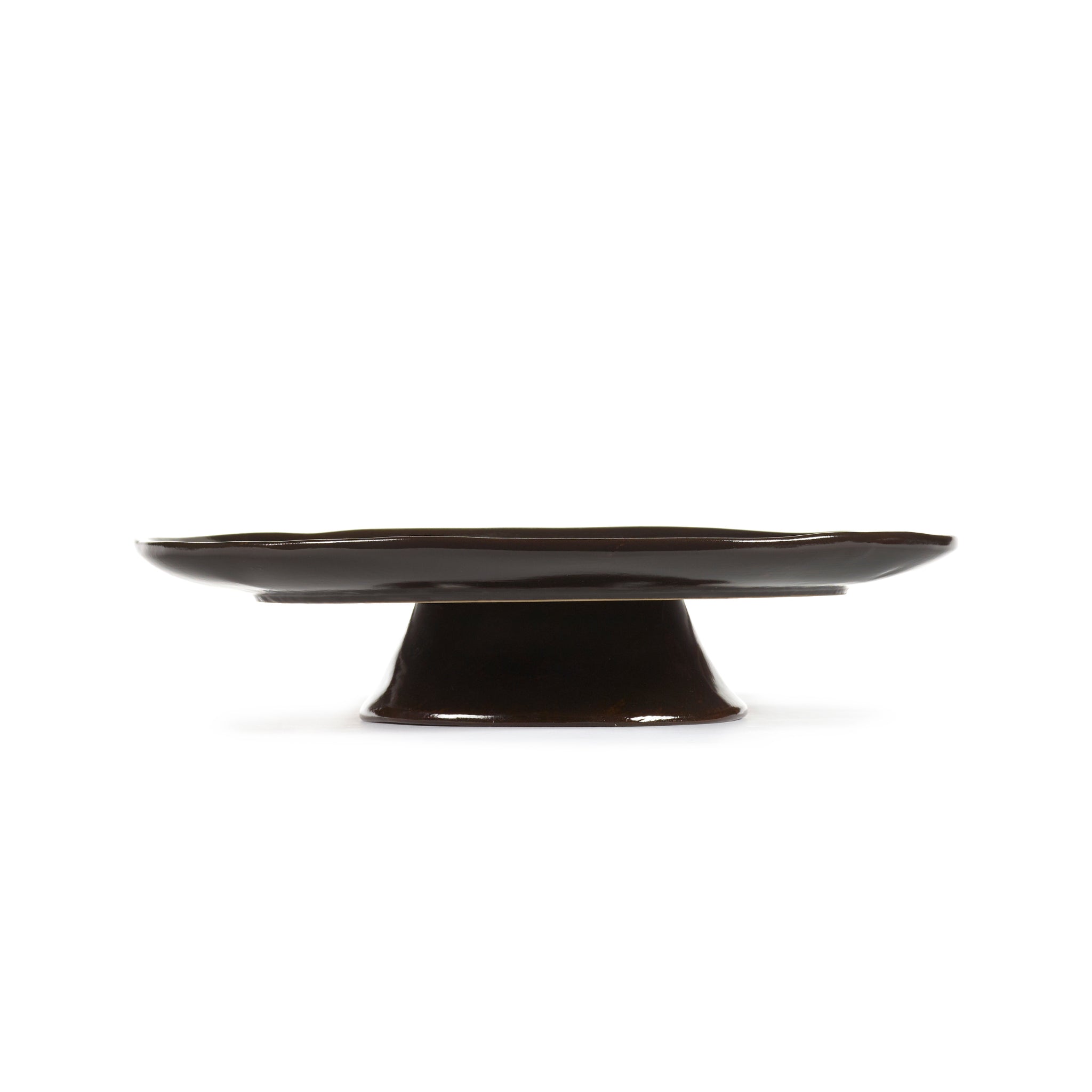 De Serax La Mère Taartschaal Ebony D30 is een donkerbruine keramieken taartplateau van Serax, ontworpen door Marie Michielssen, met een brede platte bovenkant en stevige uitlopende voet, op een effen witte achtergrond.