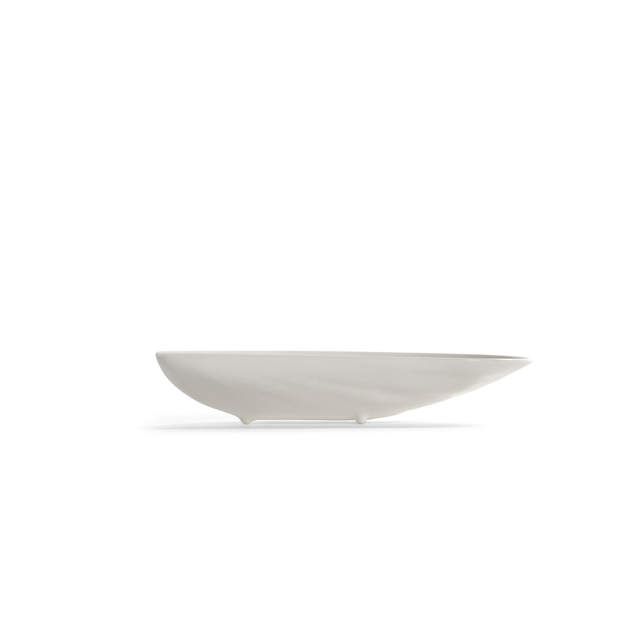 De Serax Wouters & Hendrix Marcel Schaal Wit 17/7 is een minimalistische kom van wit keramiek met een modern asymmetrisch ontwerp, zachte rondingen en kleine pootjes van Serax, afgebeeld op een effen achtergrond.