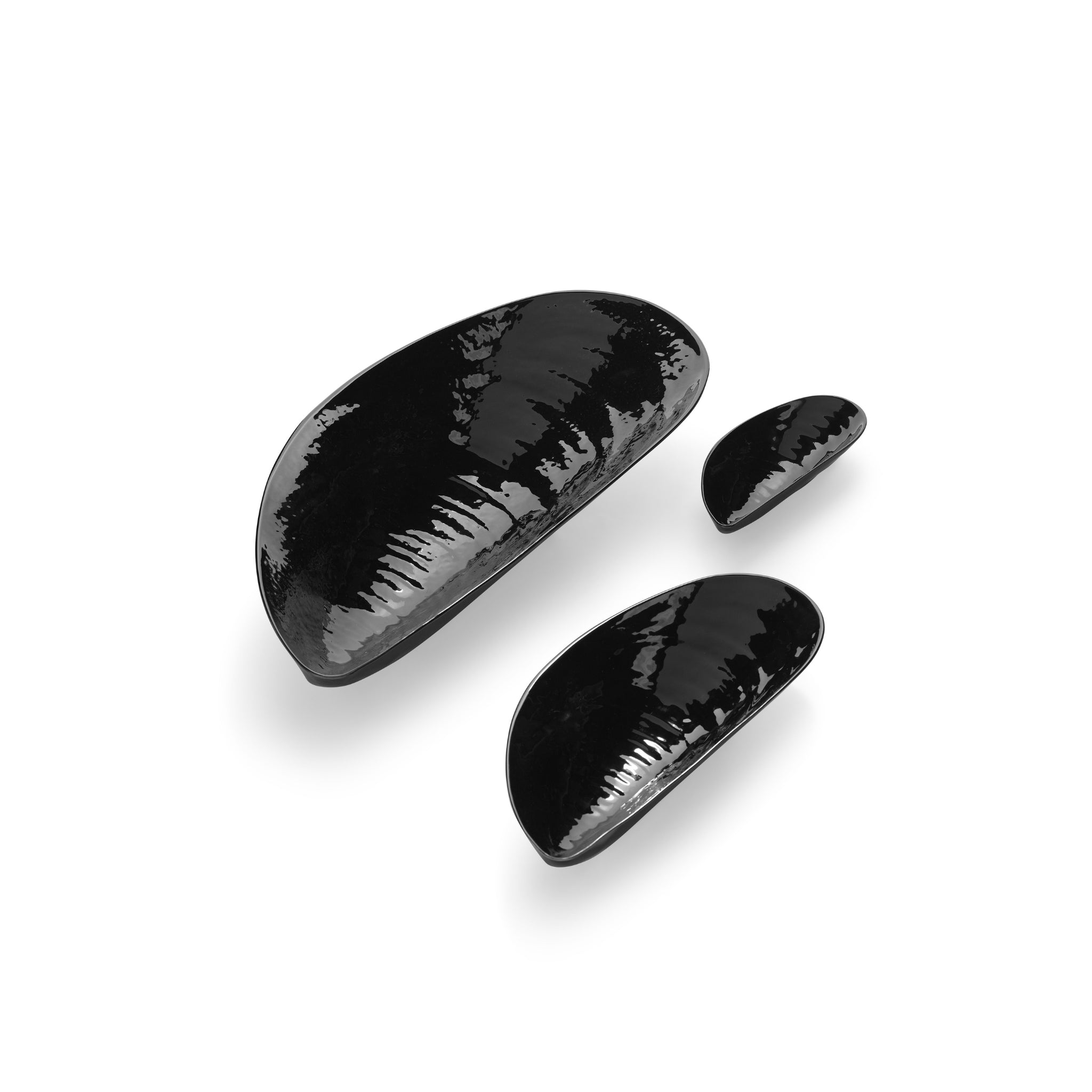 Drie glanzend zwarte Marcel Schaal Zwart 30/14 schelpen van Serax Wouters & Hendrix zijn gerangschikt op een witte achtergrond, waardoor er zachte schaduwen onder liggen.