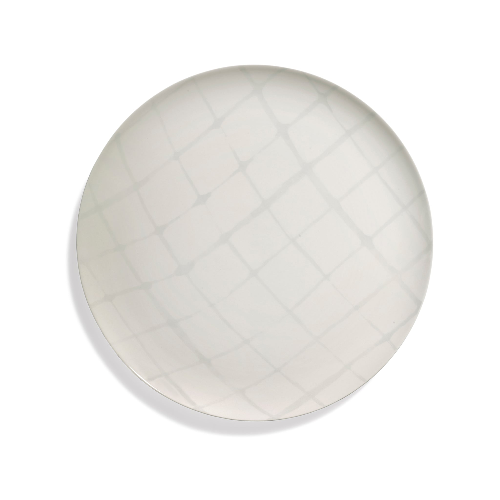 De Serax Zuma Laag Bord Salt D33 is een rond, wit bord van keramiek met een subtiel kriskraspatroon op het oppervlak, van bovenaf afgebeeld tegen een effen witte achtergrond. Merk: Serax.
