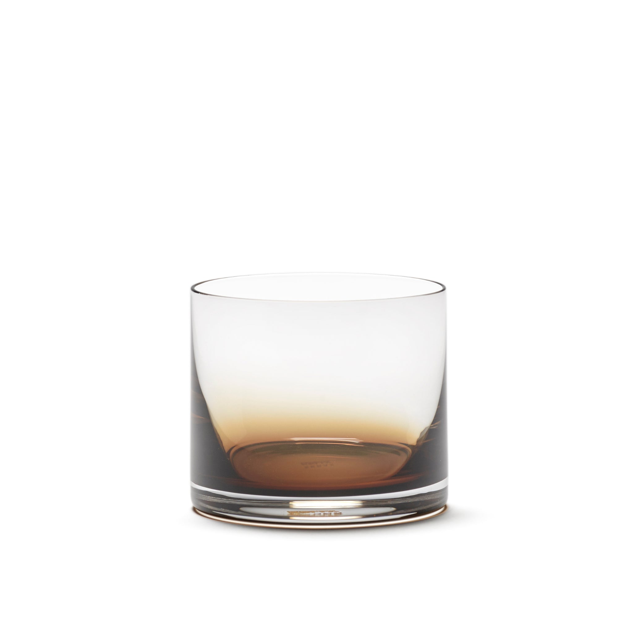 De Serax Zuma Whiskyglas Amber 20 cl van Serax is een helder glazen beker met een subtiele amberkleurige tint aan de onderkant, tegen een effen witte achtergrond.