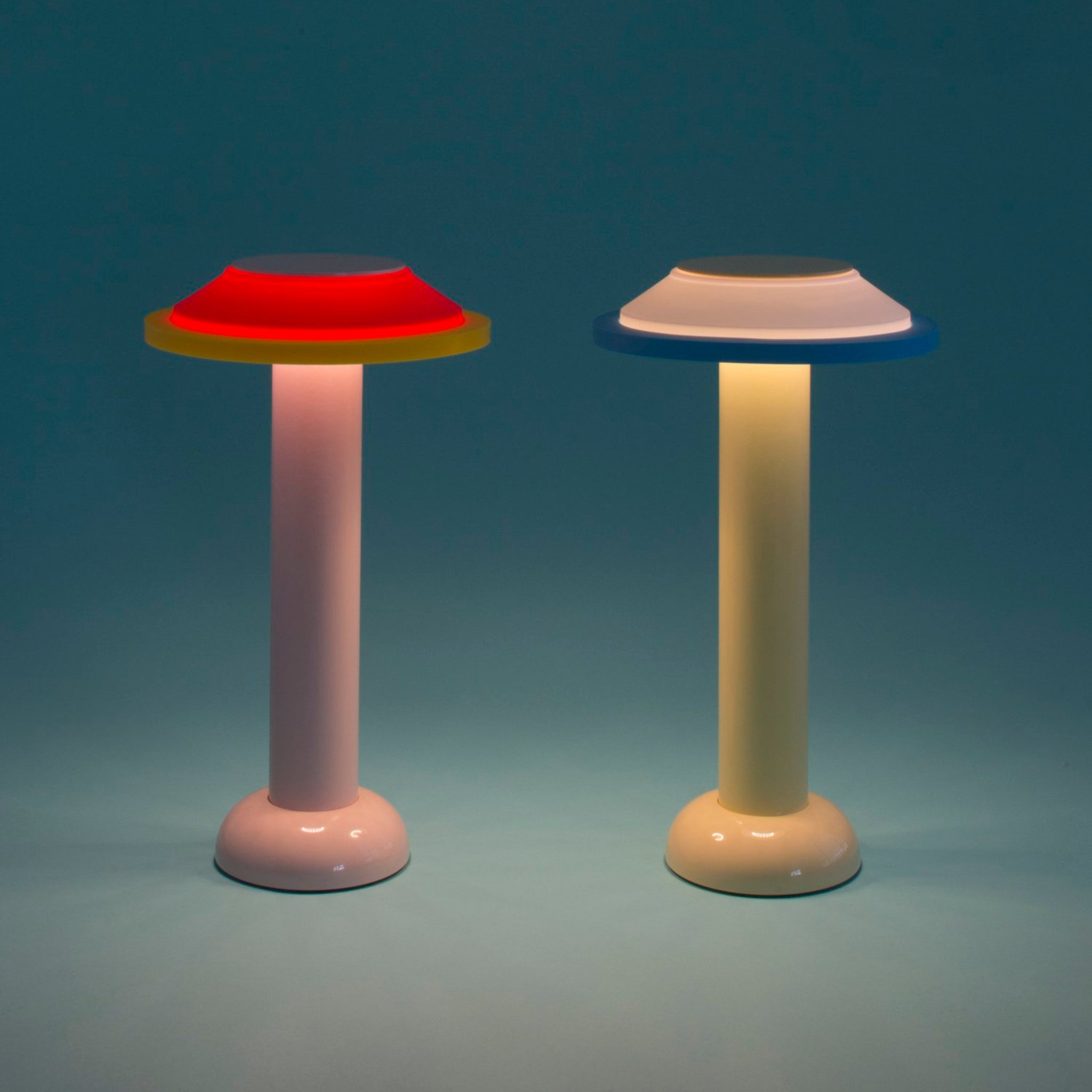 De Sowden PL2 Lamp LED Oplaadbaar Geel van Sowden, met zijn ronde voet en brede schijfvormige kap, heeft een dimbaar ontwerp in geel en wordt getoond verlicht tegen een blauwe achtergrond.