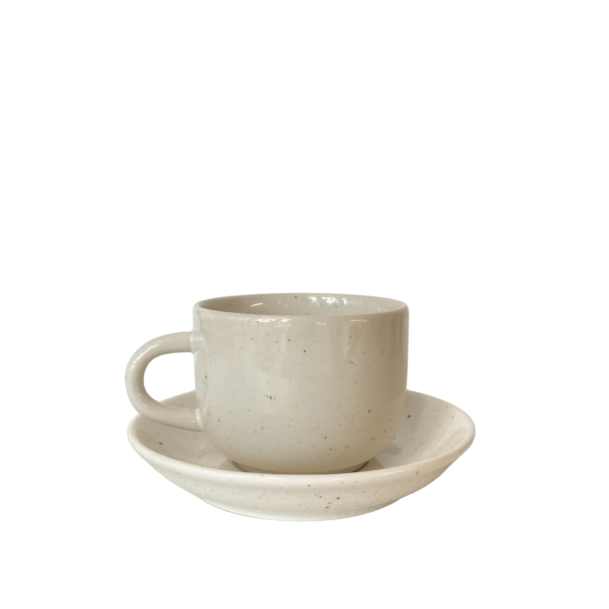 De Stock Antwerpen Koffiekop + Schotel Wit Spikkel, een eenvoudige lichtbeige keramische kop met handvat en bijpassende schotel van Stock Antwerpen, wordt getoond tegen een effen witte achtergrond.