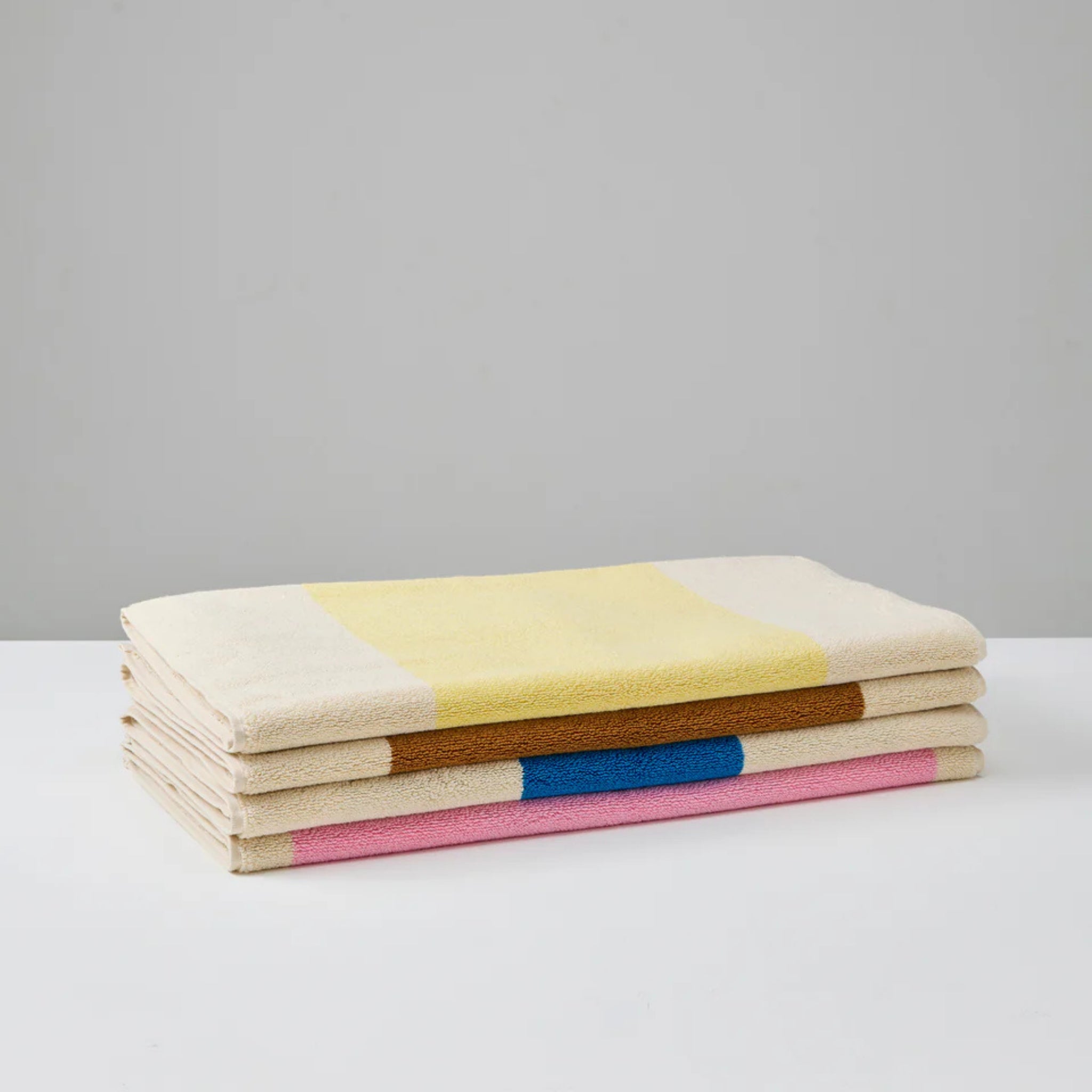 Een Suite 702 Badmat Aqua Donkergroen 50/80 in diepgroen wordt gevouwen getoond op een wit oppervlak tegen een effen grijze achtergrond.