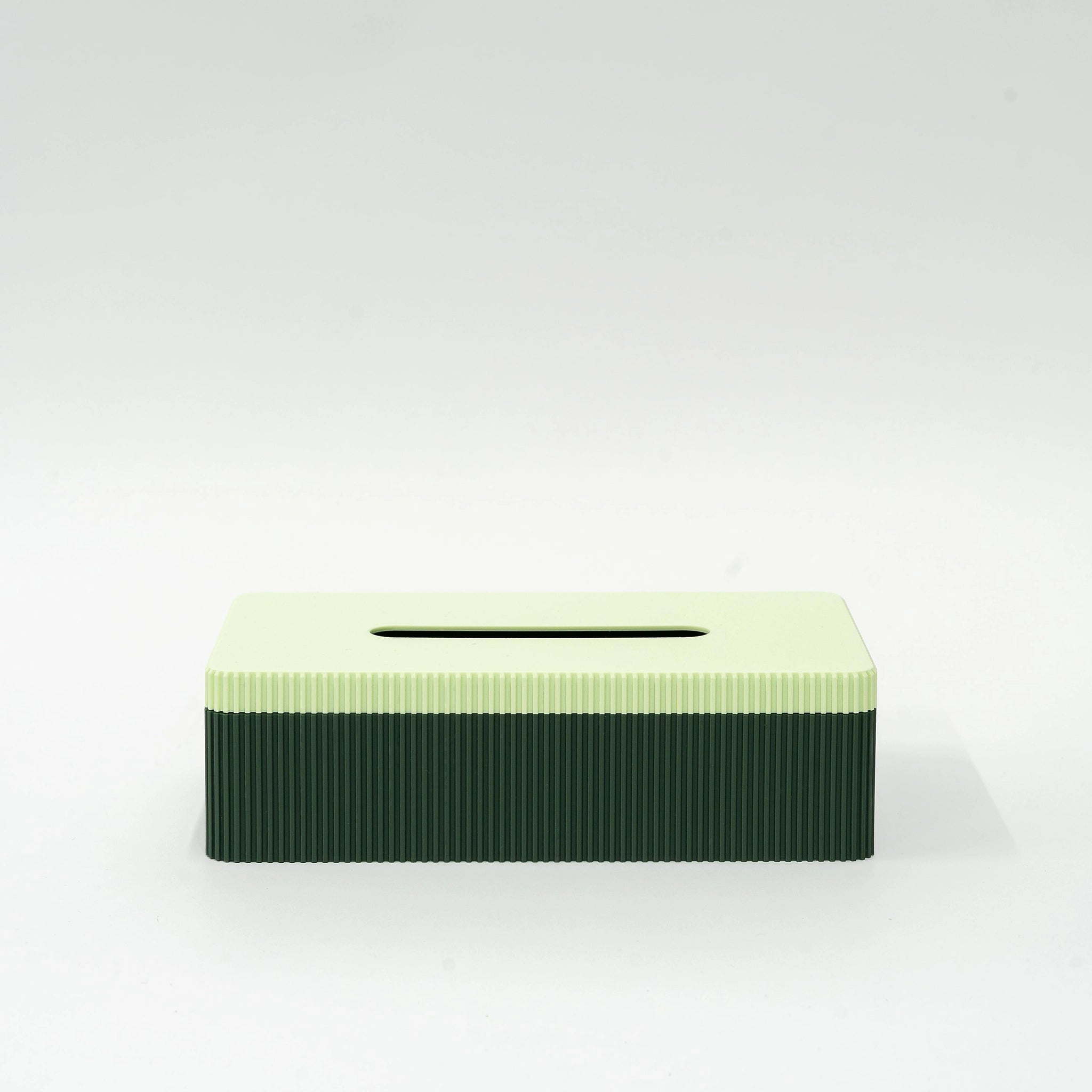 De Wavy Tissuebox Highland Groen/Munt van Wavy Design Studio heeft een rechthoekig, 3D-geprint ontwerp met een lichtgroene bovenkant en donkergroene geribbelde zijkanten, weergegeven op een effen wit oppervlak.