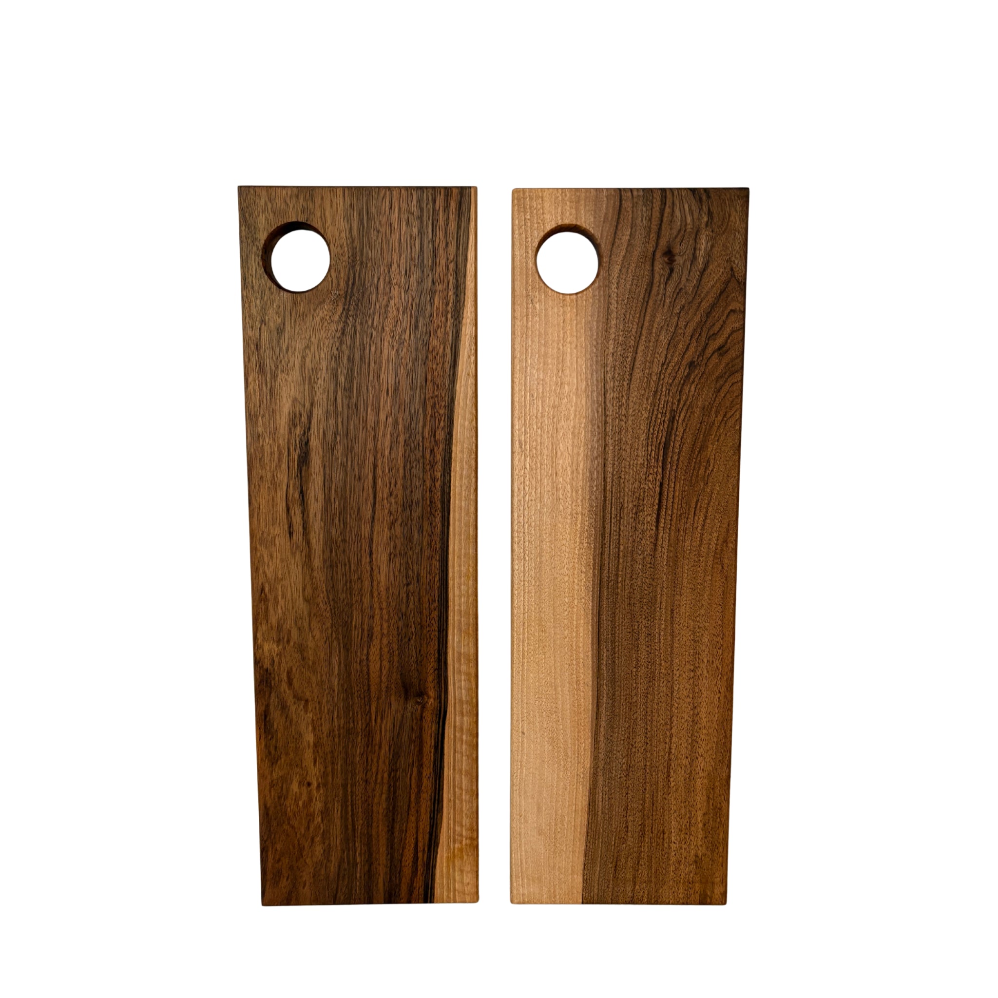 Twee Weshwood Serveerplanken Europese Notelaar 17/54 staan rechtop naast elkaar. Elke plank van het merk Weshwood heeft afgeronde hoeken, een ronde opening bovenaan en unieke houtnerfpatronen in bruine tinten.