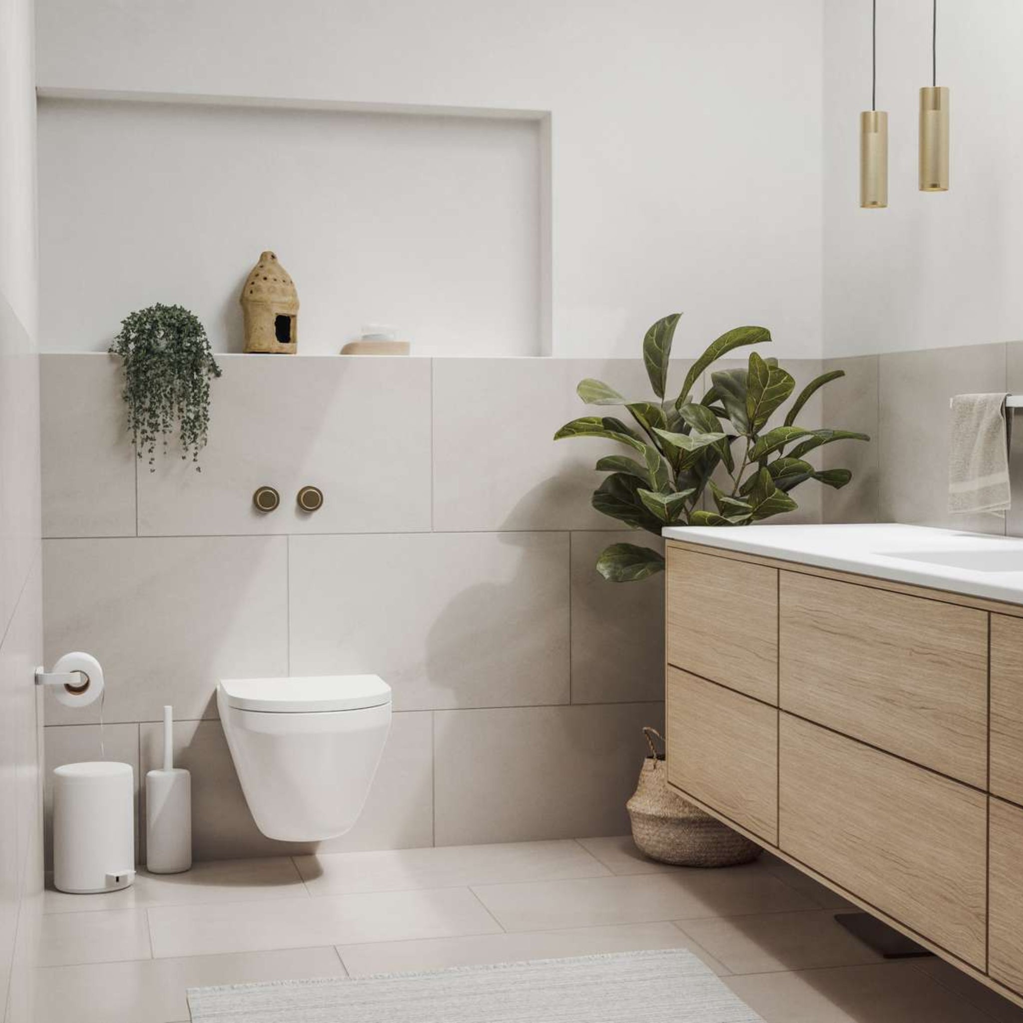 Minimalistische badkamer met lichte tegels, wandcloset, houten badmeubel, potplant en hanglampen. De Zone Denmark Rim Toiletrolhouder Wit voegt een stijlvolle touch toe, terwijl witte accenten en een handdoek de strakke moderne look afmaken.