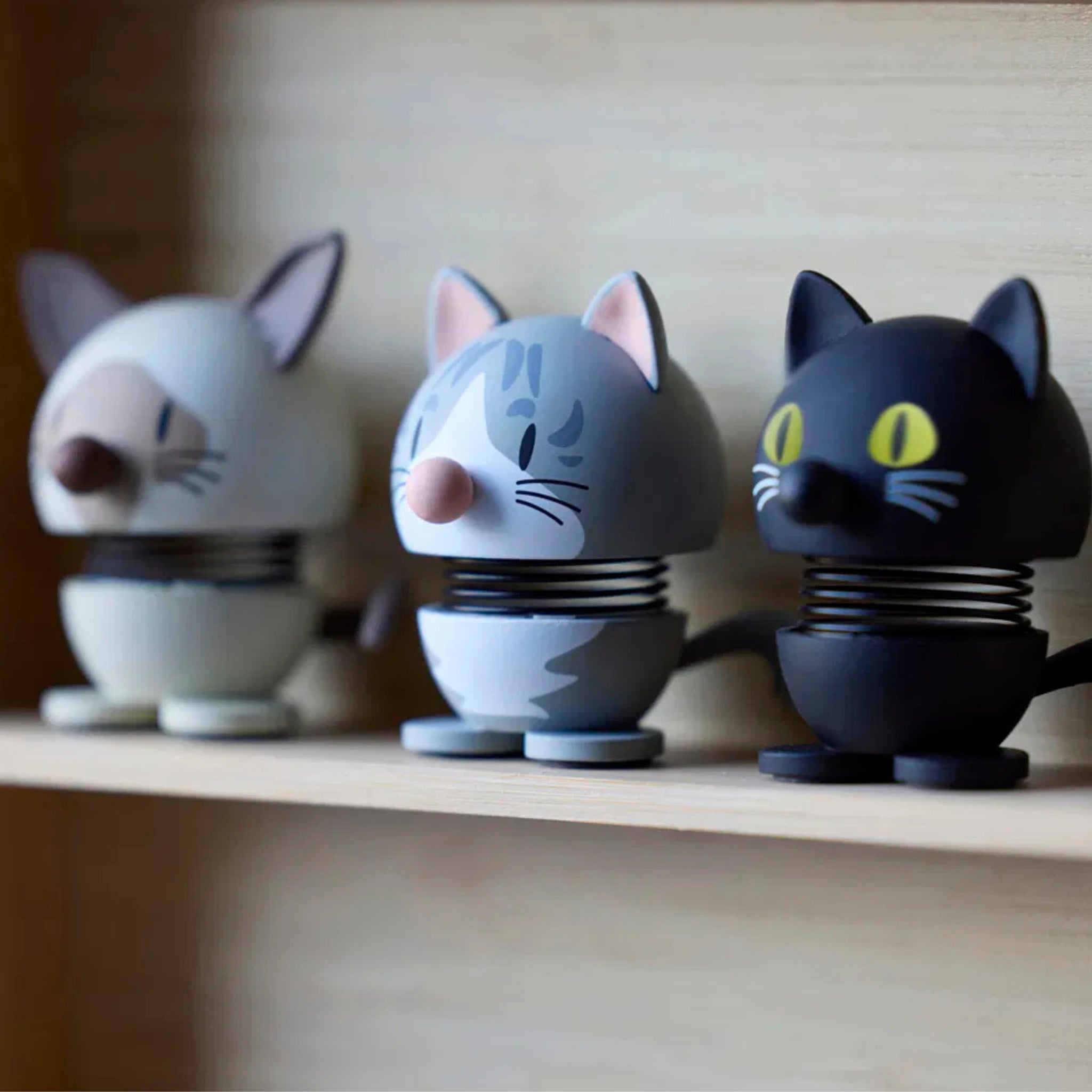 De Hoptimist Siamese Kat Beige XS van Hoptimist, met zijn ronde lijf en verende nek, voegt een speels tintje toe aan je inrichting - een perfect cadeau voor kattenliefhebbers of een charmant accent op elke plank.