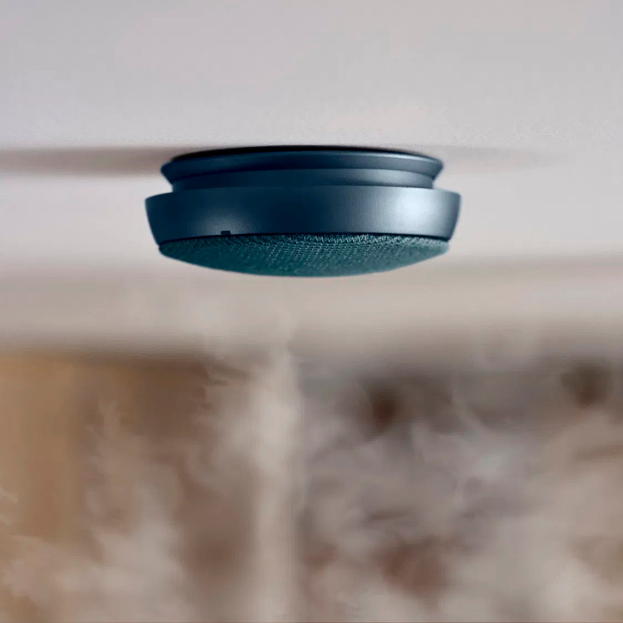 Een slanke Jacob Jensen Optische Rookmelder Blauw D10 is aan het plafond gemonteerd, met daaronder rookdetectie. Dit toont de stijlvolle blauwe rookmelder van Jacob Jensen in actie.