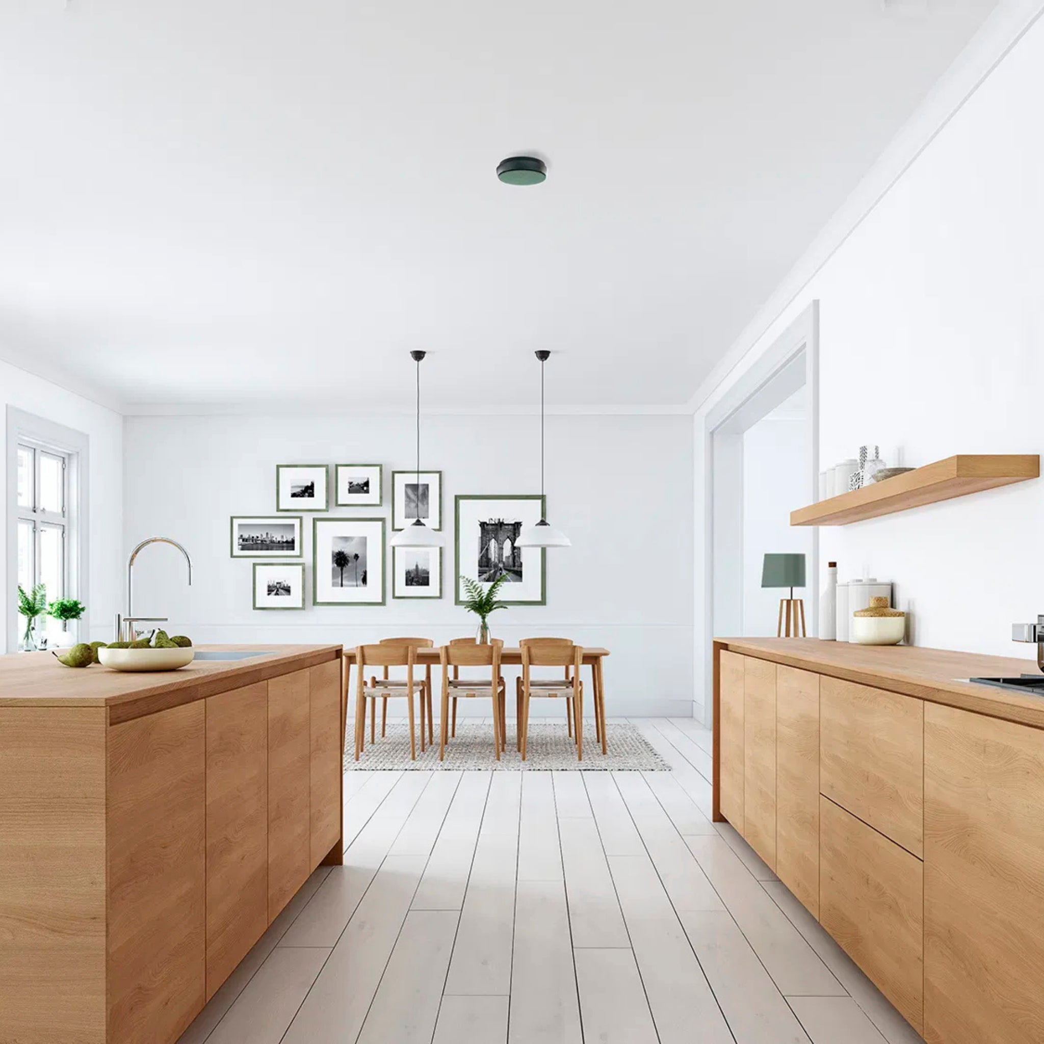Moderne keuken en eethoek met lichthouten kasten en grote ramen, met Scandinavisch design, minimalistische inrichting en een discrete Hoptimist Jacob Jensen Optical Rookmelder Groen D10 die naadloos opgaat in het interieur.