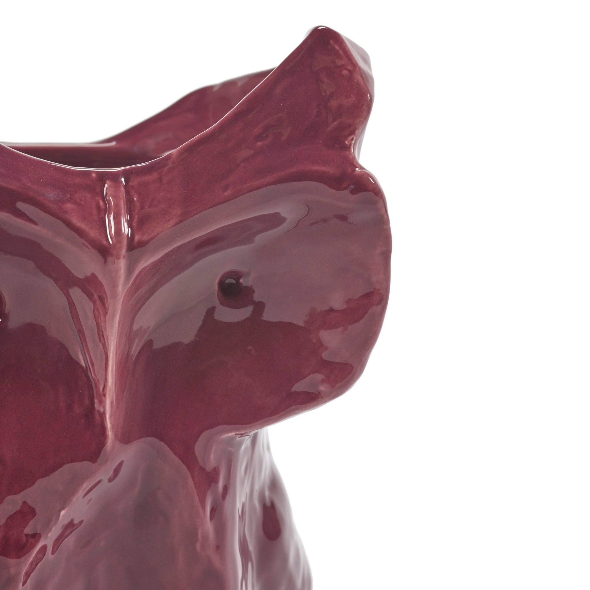 Close-up van de Serax After Midnight Uil Vaas Aubergine S, een glanzende, auberginekleurige vaas in de vorm van een uil van Serax, met de nadruk op het gladde oppervlak en de gedetailleerde kenmerken zoals het hoofd, de snavel en één oog.