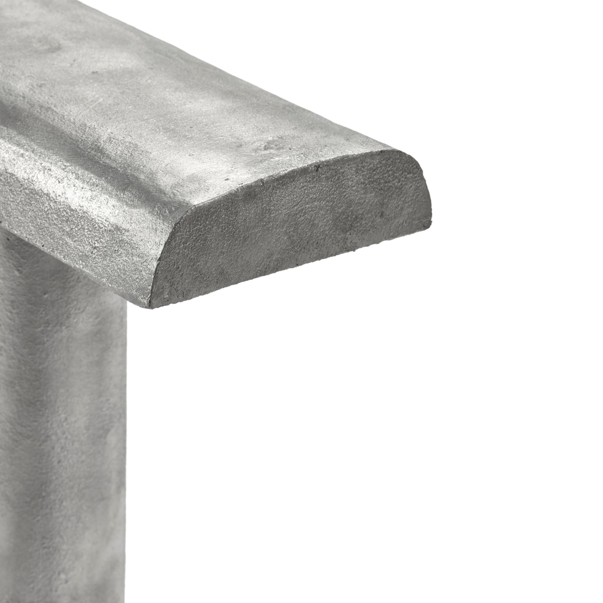 Een close-up van de Serax Fck Tafellamp Staal Grijs van Serax, met de nadruk op de metalen T-vorm, het gestructureerde stalen oppervlak en het minimale, op Brutalist geïnspireerde ontwerp.