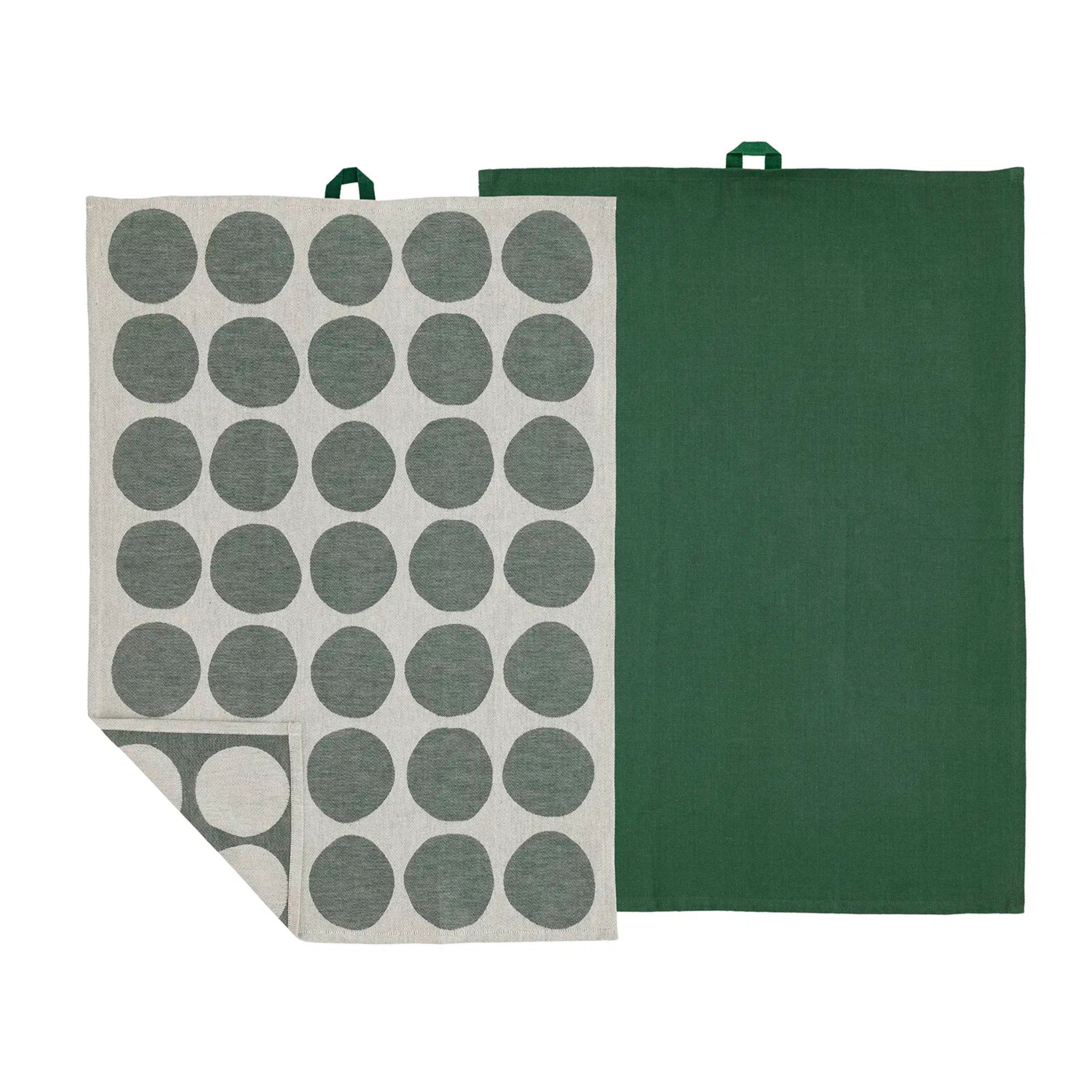 De Södahl Bubbles Theedoek Groen 2 st. set bestaat uit een effen groene handdoek en een lichte handdoek met grote donkergroene stippen, beide voorzien van een kleine groene ophanglus voor een stijlvolle Scandinavische keukenaccessoire touch.