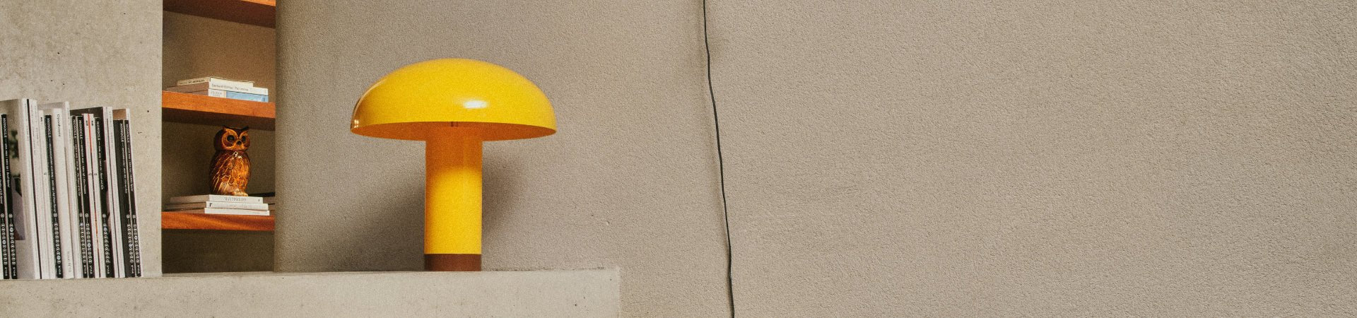 Gele HK Living lamp die op een kast in de living staat gepresenteerd.