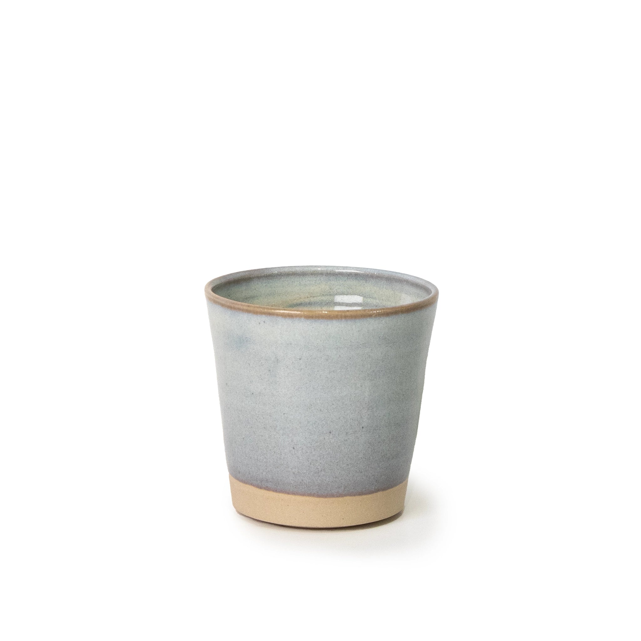 De AB Ceramics Beker Wit Opaal 20 cl is een handgemaakte keramische beker van wit steengoed klei met een gladde, licht grijsblauwe glazuur en natuurlijke beige basis, gefotografeerd tegen een witte achtergrond.