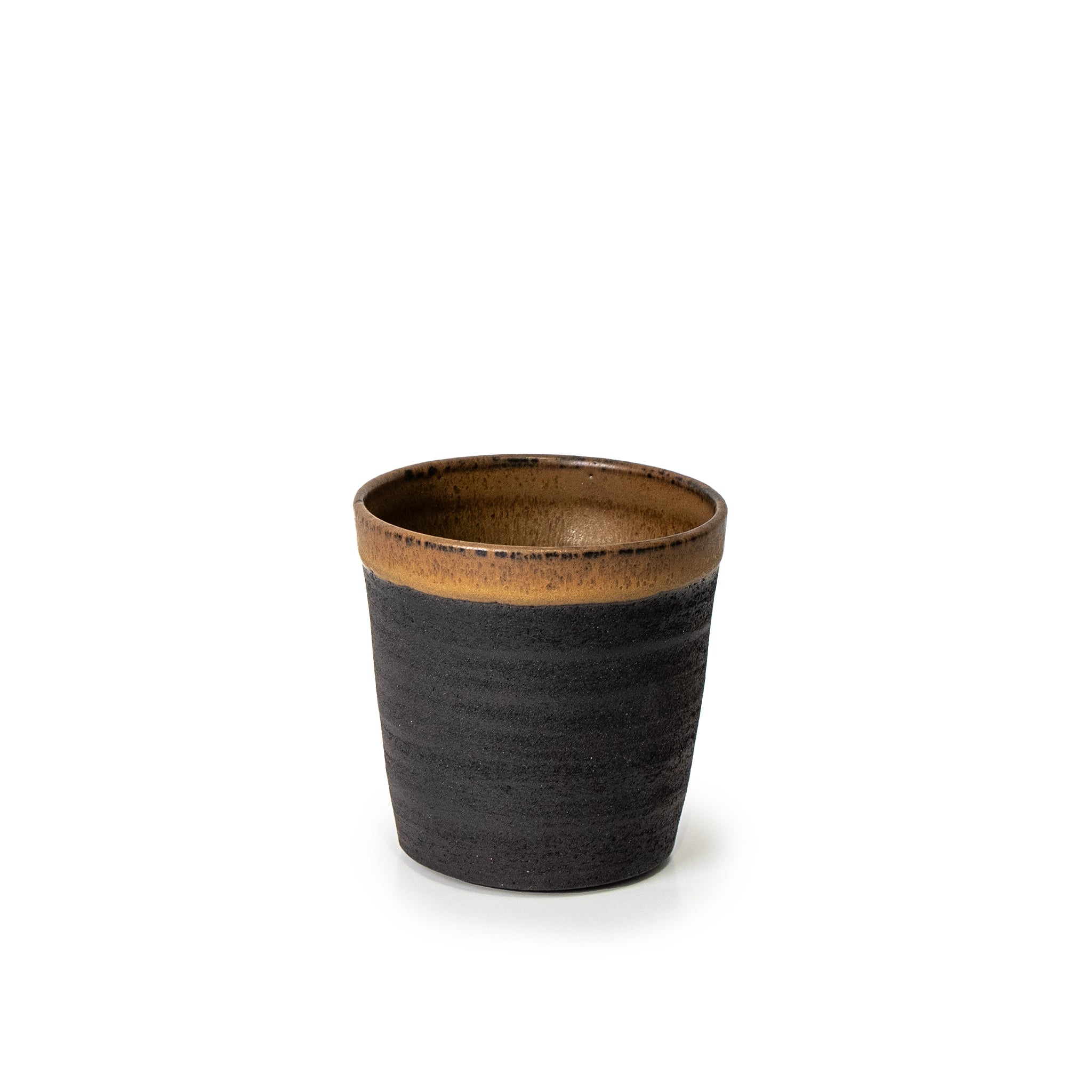 De AB Ceramics Beker Zwart Roodbruin 20 cl is een uniek handgemaakt keramisch kopje met een mat donkerbruine body en een glanzende, lichtbruine rand, van zwart steengoed klei, gepresenteerd tegen een witte achtergrond.