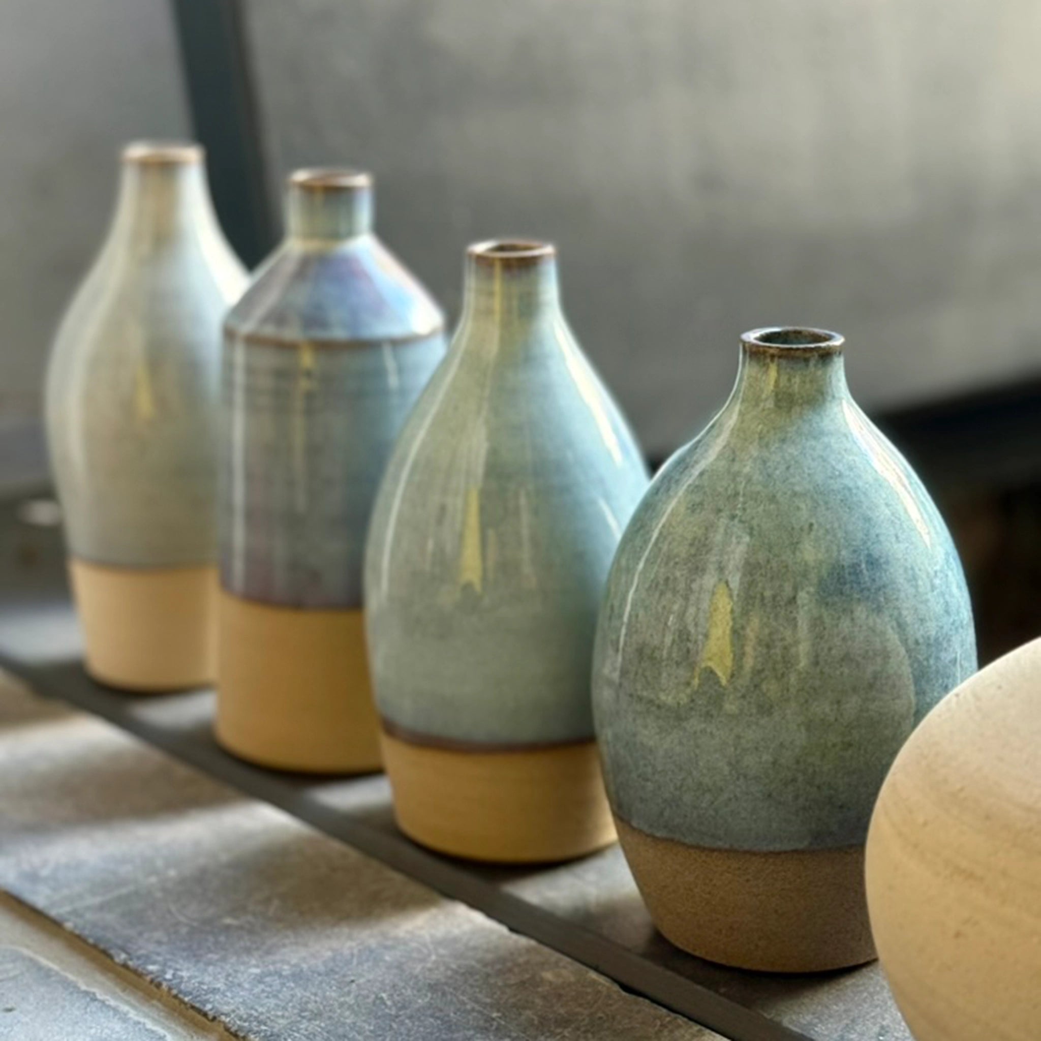 De AB Ceramics Olijfolie Fles Geel Opaal 61 cl van AB Ceramics heeft een slank opaalgeel glazuur, het gladde keramische oppervlak wordt benadrukt door natuurlijk licht als het elegant op een richel staat.