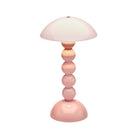 De Addison Ross Bobbin Lamp LED Oplaadbaar Roze heeft een glanzend, modern ontwerp met gestapelde bollen en een koepelkap, waardoor het de ideale sfeerverlichting is voor elke ruimte.