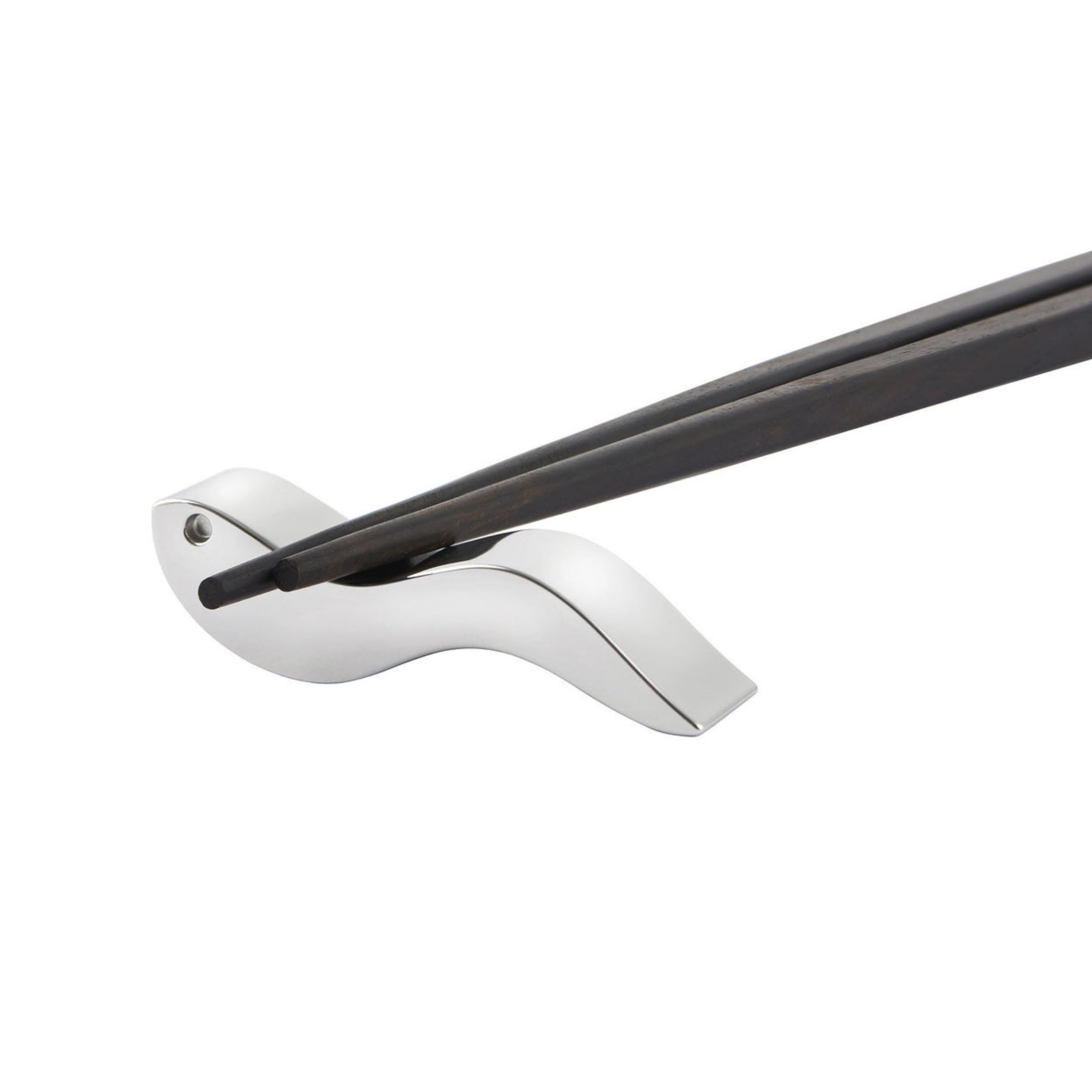 Een paar Alessi Anna eetstokjes rust op een slanke, zilveren vogelvormige houder tegen een witte achtergrond - een elegant tafelaccessoire van Alessi.