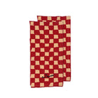 De Byon Theedoek Love Rood 2 st. zijn twee rechthoekige rode servetten gemaakt van biologisch katoen, met een beige, ongelijkmatig dambordpatroon en "Bon Appetit" geborduurd in zwart op de onderste hoek.