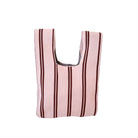 De Caro Antwerp Handtas Double Dash 2.0 Roland Larose is een herbruikbare geweven draagtas met verticale kastanjebruine strepen op een lichtroze achtergrond, ontworpen om stijlvol en duurzaam mee te nemen.
