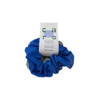 De Caro Antwerp Caro The Scrunch Club Scrunchie 2 st. is een blauwe reflecterende 100% polyester scrunchie met een care tag, afgebeeld op een effen witte achtergrond - ideaal als fiets accessoire of om het haar vast te zetten bij elk weertype.