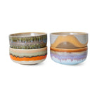Vier HK Living 70s Ceramics Dessertkom Reef kommen worden getoond gestapeld in twee stapels; elke keramische kom heeft unieke, getextureerde glazuren en aardetinten geïnspireerd op jaren '70 design.
