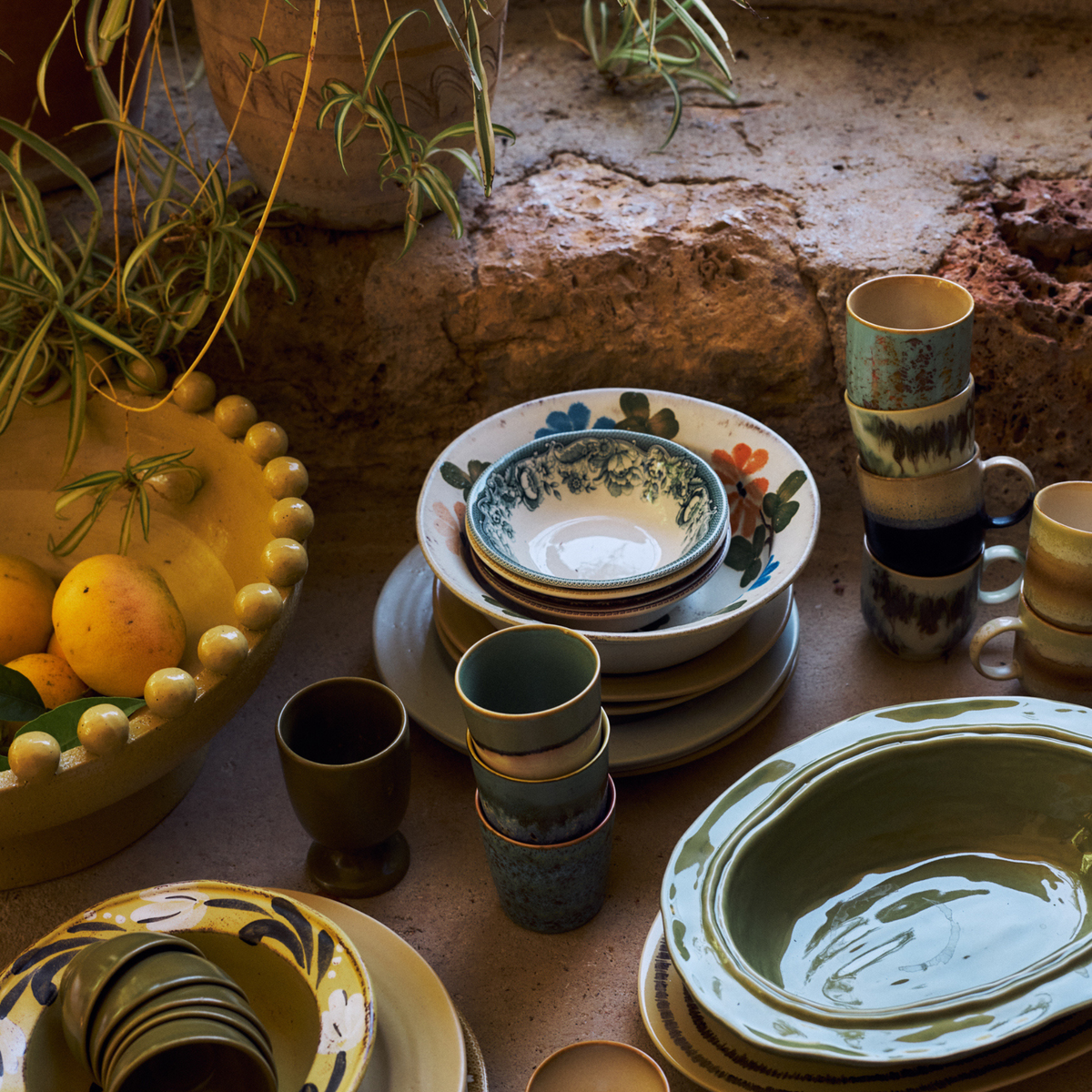 Gedekte tafel met HK Living 70s Ceramics servies en gestapelde koffiekoppen Agave, Zingy en Gelato