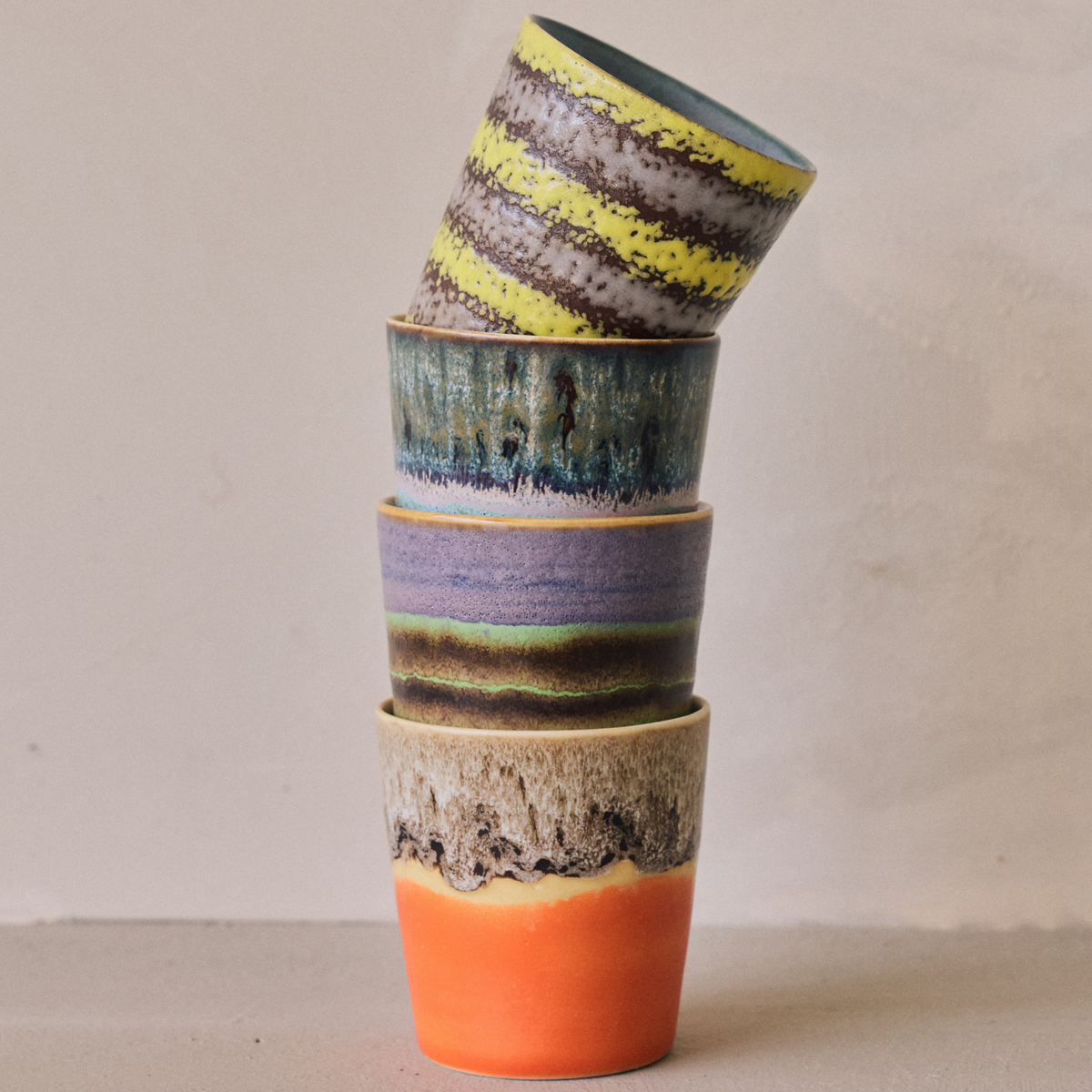 Stapel HK Living 70s Ceramics Koffiekoppen Layers, Birthstone, Mochi en Fierce tegen een lichte muur