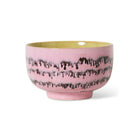De HK Living 70s Ceramics Noodle Kom Bubble D13 heeft een roze glazuur met donkere golvende strepen, een contrasterende lichtgele binnenkant en een eenvoudig rond ontwerp met een kleine verhoogde basis.