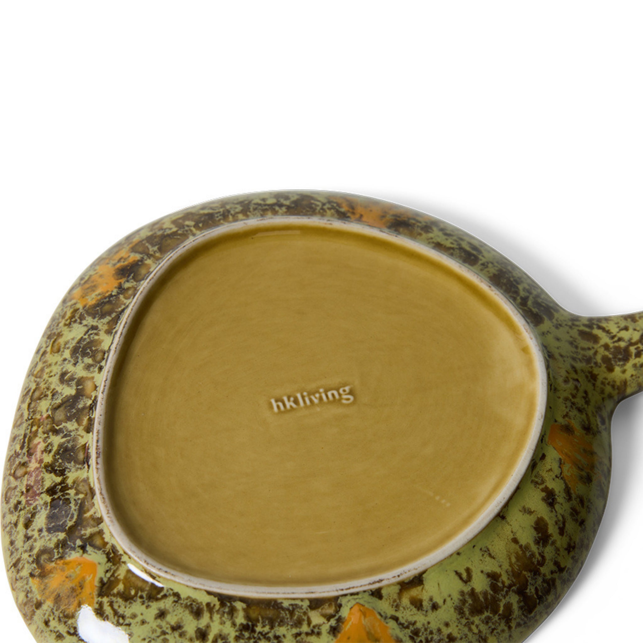 De afbeelding toont de onderkant van een afgeronde driehoekige HK Living 70s Ceramics Schotel Fjord, met een bruine basis gestempeld met HK Living, en groen glazuur met bruine en oranje spikkels rond de randen.