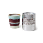 Een HK Living Kerst Special Geurkaars Frosted Leaves met blauwe, witte en kastanjebruine strepen staat naast een glanzend zilveren cilindervormige pot met het label "70s Ceramics Christmas Special Frosted Leaves" van HK Living.