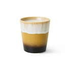 De HK Living Kerstspecial Geurkaars Winter Woods is een keramische kaars in een kopje met een bruin en zwart kleurverloop op de basis, afgewerkt met een glanzend witte rand. De lont is gecentreerd. De achtergrond is egaal wit.