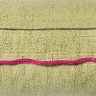 De HK Living Kussen Mansion Lichtgroen 50/30 heeft stof met textuur, een zichtbare naad en een golvende, felroze draad die horizontaal over het midden loopt.