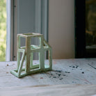 Het HK Living Papieren Object: After Constructivism van HK Living, met zijn abstracte rechthoekige kaders, staat op een wit gedekte tafel bij een zonovergoten raam - een ideaal modern accent.