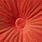 Close-up van de HK Living Ripple Rond Kussen Sienna D50, met een verhoogd midden en gestikte lijnen op zachte, fluweelzachte oranjerode stof.