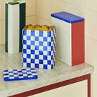 De Hay Blikken Doos Groen Off-White Slim op een marmeren aanrecht, naast een blauw geblokte doos vol pasta en een rood-witte blikken doos.