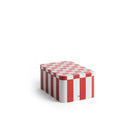 De Hay Blikken Doos Rood Off-White S van Hay is een rechthoekige metalen doos met rood-witte verticale strepen en een geruit deksel, met een klein HAY-logo, tegen een effen witte achtergrond.