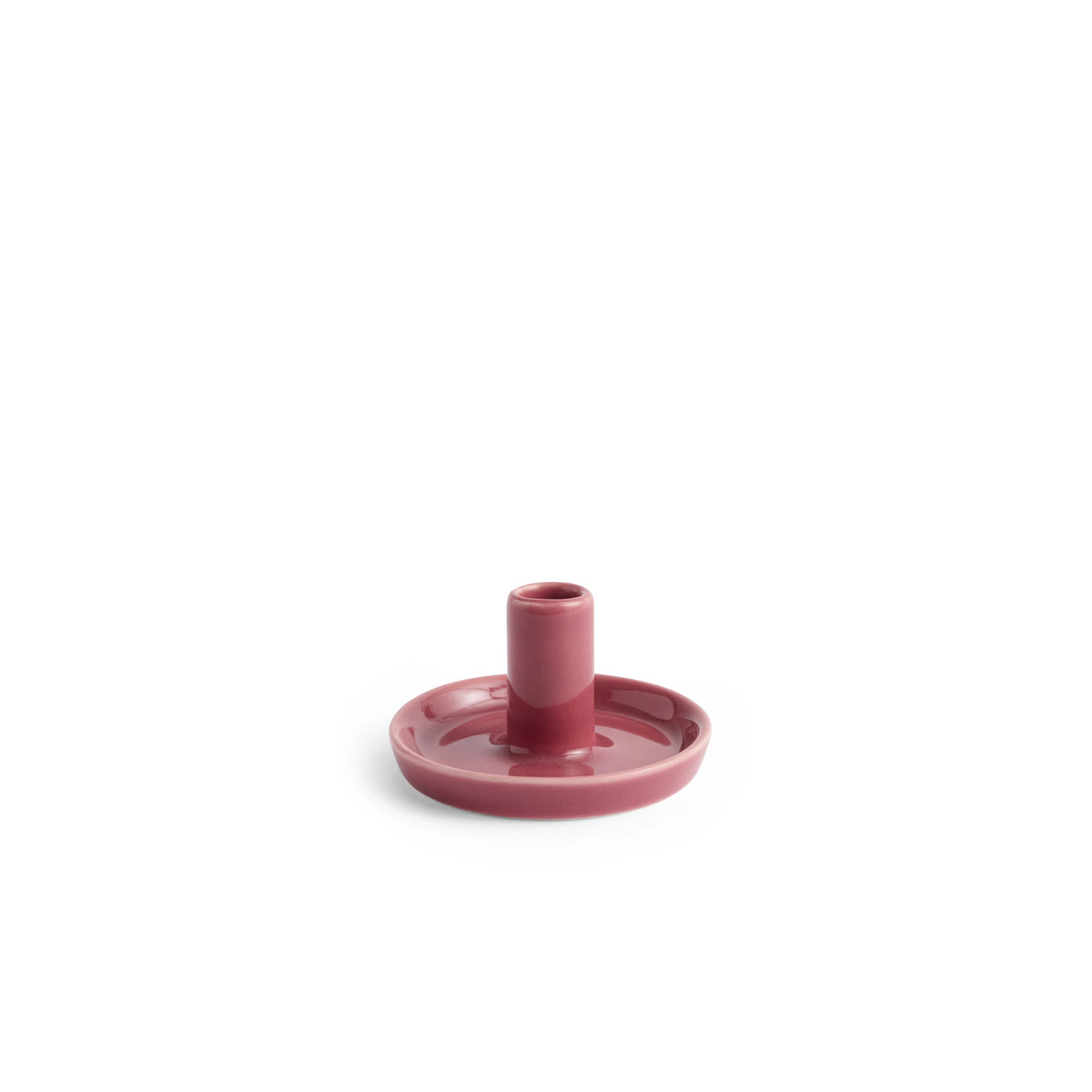 De Hay Disc Kandelaar Bessenroze XS van Hay is een lage, ronde roze kandelaar van aardewerk met een kleine opstaande houder, afgebeeld tegen een effen witte achtergrond.