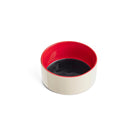 Een kleine, ronde Hay Hondenbak Blauw Rood D15 van Hay, met een witte buitenkant en rode binnenkant, is gevuld met een donkere vloeistof - waarschijnlijk sojasaus - en wordt tentoongesteld tegen een effen witte achtergrond.