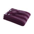 De Hay Duo Plaid Pruim 130/180 van Hay is een opgevouwen wollen plaid met brede strepen in pruim- en bordeauxtinten en franjes aan de rand, tegen een effen witte achtergrond.
