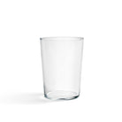 Een heldere Glas Helder L beker van Hay staat in het midden op een witte achtergrond, met een vage schaduw aan de linkerkant - een perfect voorbeeld van minimalistisch glazen.