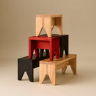 Vier Hay Manolito Kruk Bank Naturel Lang stukken van Hay zijn gestapeld in een evenwichtige, geometrische opstelling tegen een neutrale beige achtergrond, die hun minimalistische ontwerp in naturel bank afwerking laten zien.