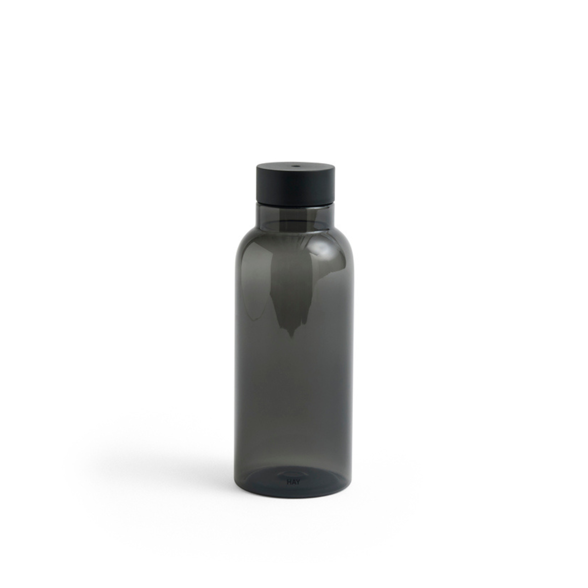 De Hay Miz Waterfles Charcoal 540 ml van gerecycled PET is een minimalistische, doorschijnende donkergrijze fles met zwarte schroefdop van het merk Hay, rechtopstaand op een witte achtergrond.