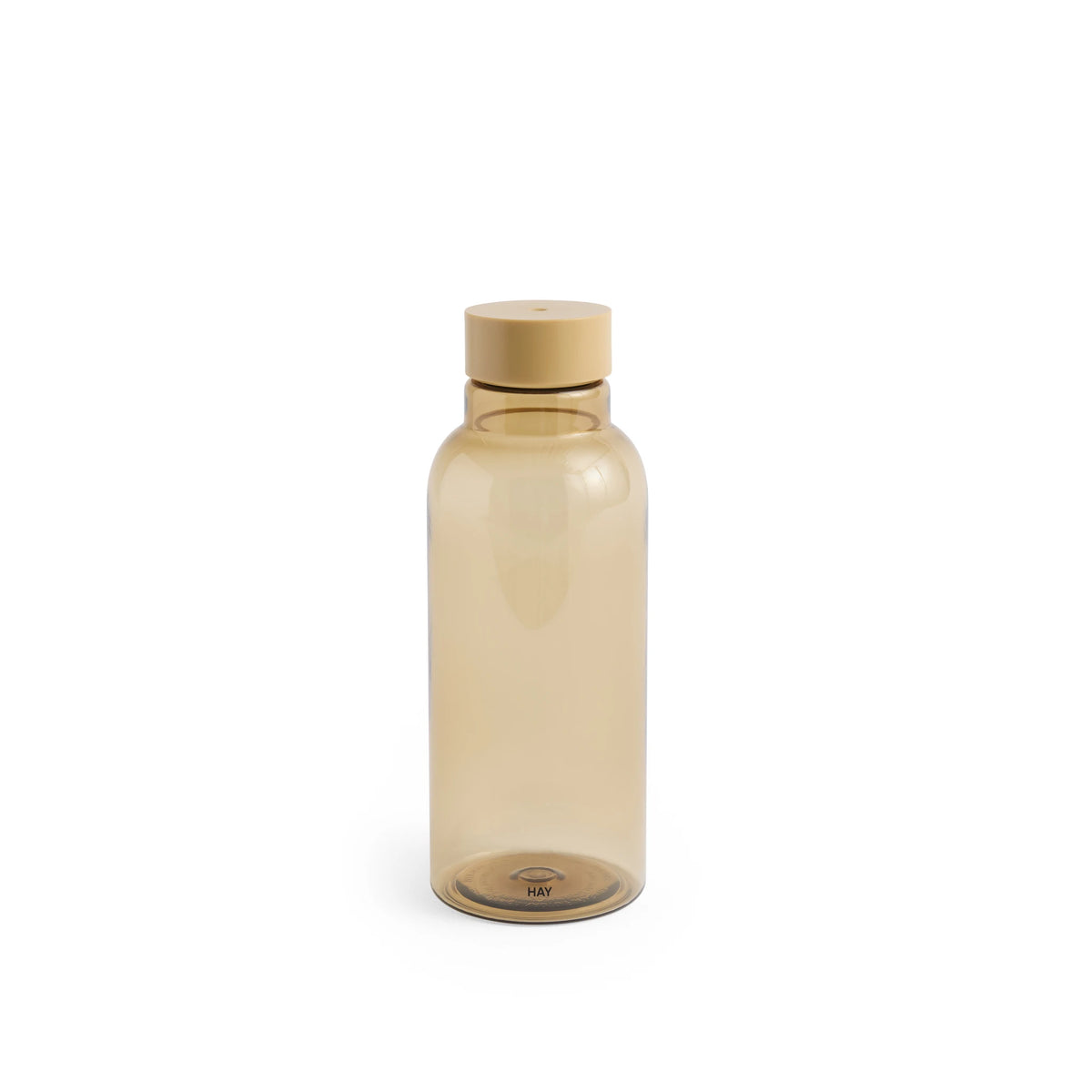 De Hay Miz Waterfles Karamel 540 ml van Hay is een doorschijnende, karamelkleurige fles met bijpassende schroefdop, rechtopstaand tegen een effen witte achtergrond.
