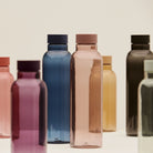 Een groep Hay Miz waterflessen in verschillende kleuren, met in het midden de Hay Miz Waterfles Mauve 720 ml met roze dop.